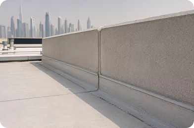 Transition seam between a roof deck and its parapet